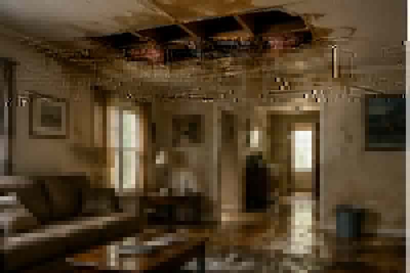 Severely water-damaged living space with standing water and ceiling damage